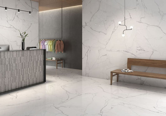 Modern interior design with marble-like flooring and walls, featuring a reception desk and seating area.