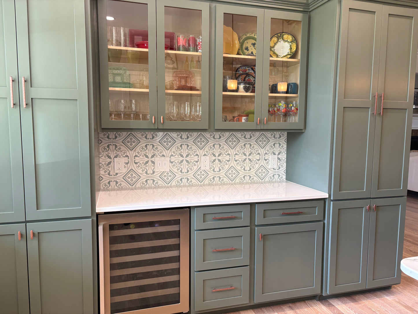 Modern kitchen with gray cabinets, white countertop, and decorative backsplash.