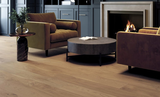 Modern living room with brown armchairs, a round coffee table, and a fireplace.