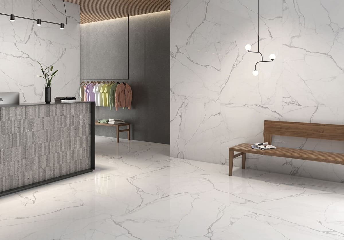 Modern interior design with marble-like flooring and walls, featuring a reception desk and seating area.