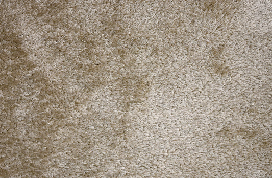 A close-up texture shot of a shaggy, high-pile carpet in a warm beige or taupe color.