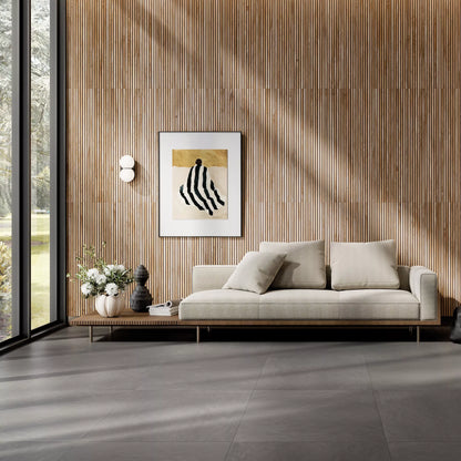 Modern living room with a light gray sofa, decorative pillows, and a wall art piece.
