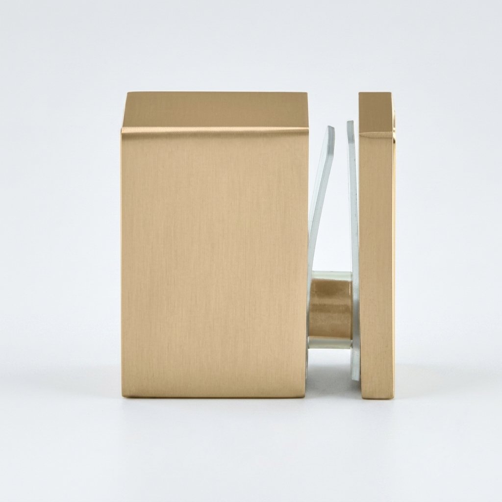 A modern square wall-mounted door handle with a brushed brass finish, shown in a side profile view with a clear glass push bar.