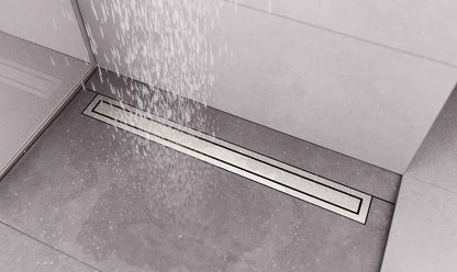 A linear floor drain installed in a tiled shower area, shown with water spraying over it.