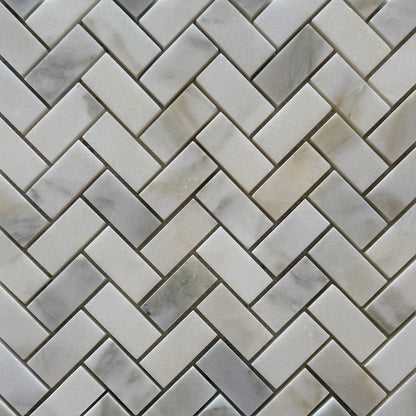 Close-up of a herringbone patterned tile with gray and white tones.