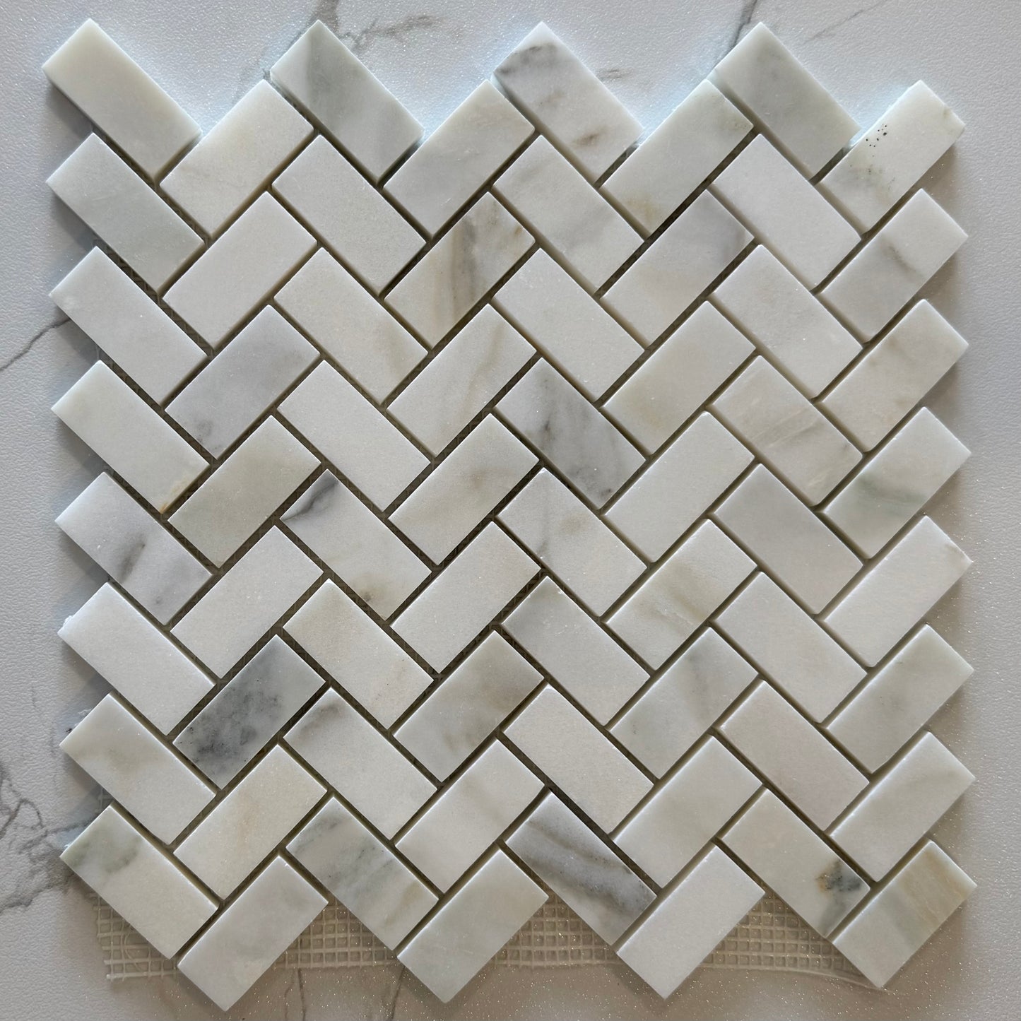 Marble mosaic tile in a herringbone pattern on a marble surface