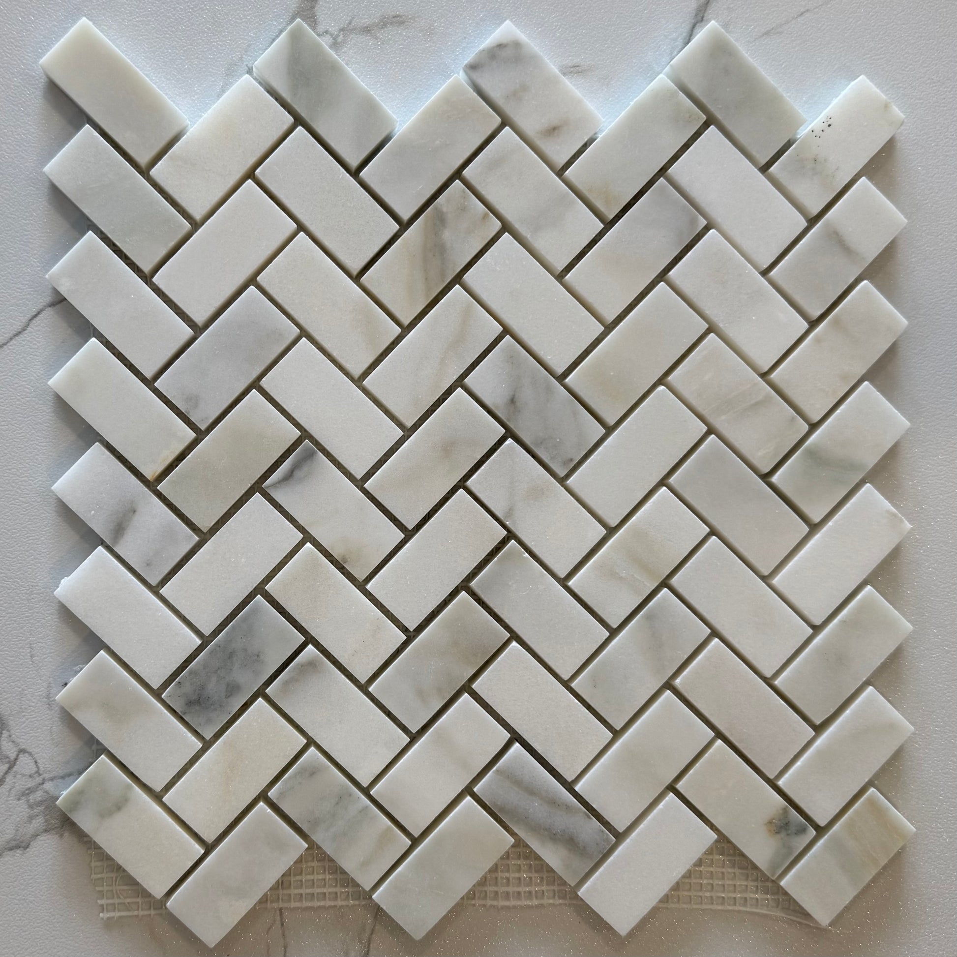 Marble mosaic tile in a herringbone pattern on a marble surface