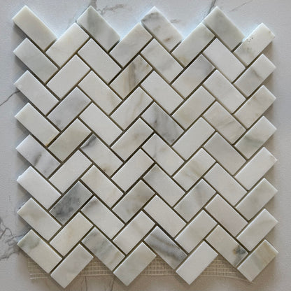 Marble mosaic tile in a herringbone pattern on a marble surface