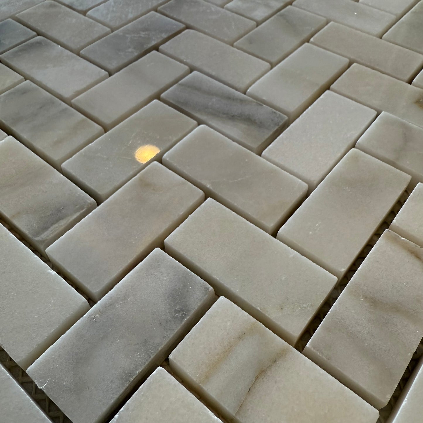 Close-up of stone tiles arranged in a herringbone pattern