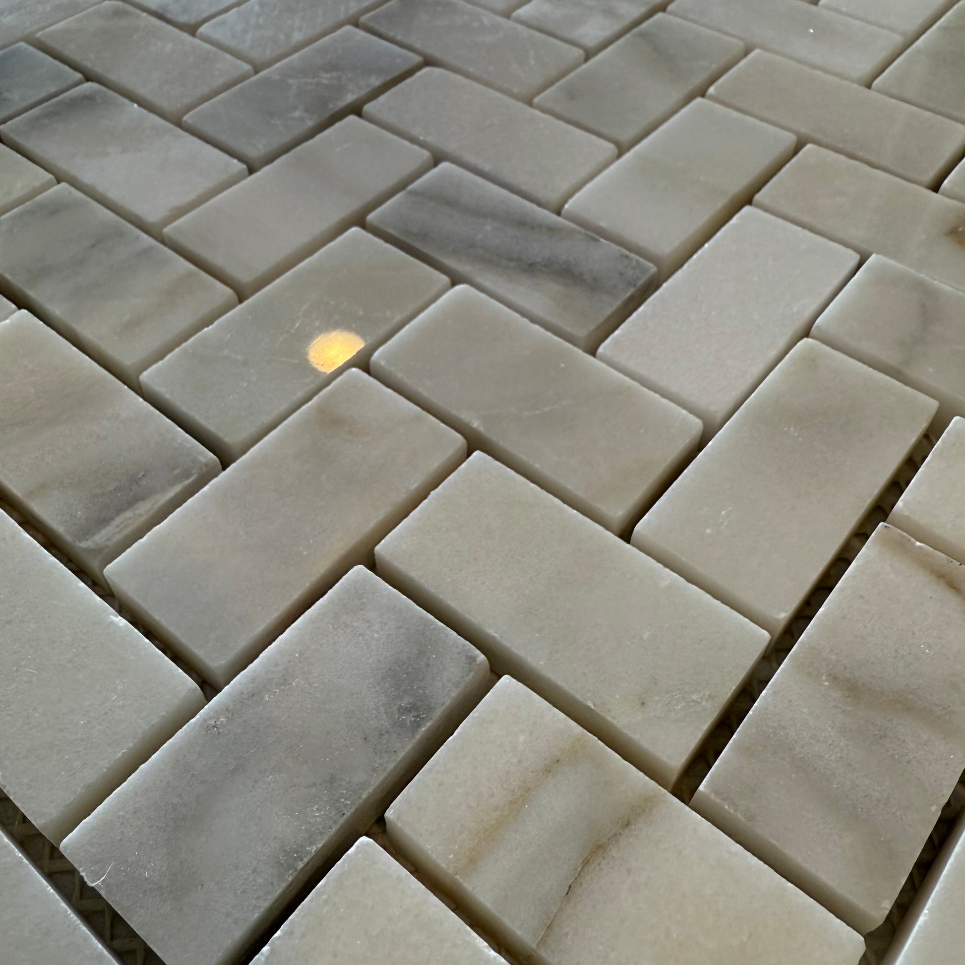 Close-up of stone tiles arranged in a herringbone pattern