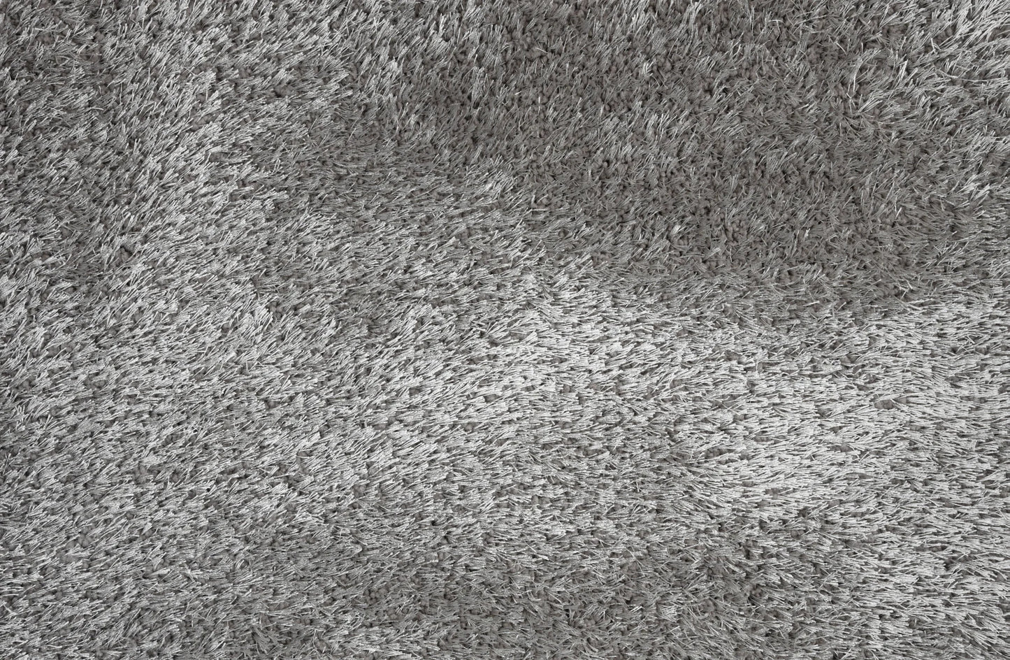 A close-up texture shot of a gray shaggy or high-pile carpet, showing the dense fibers and soft, fluffy surface.