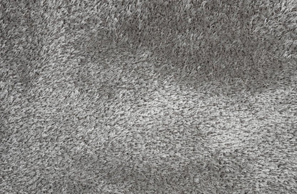 A close-up texture shot of a gray shaggy or high-pile carpet, showing the dense fibers and soft, fluffy surface.