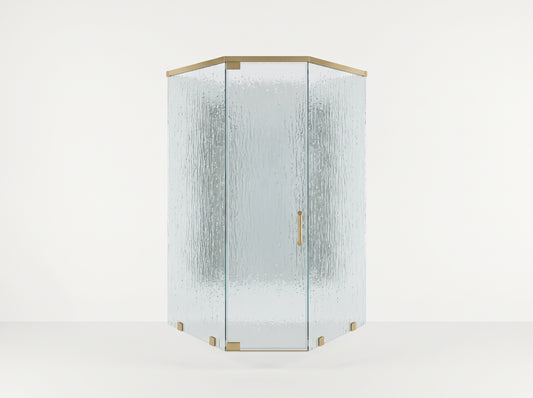 A modern hexagonal corner shower enclosure with textured, frosted glass panels and polished brass hardware, set against a clean white studio background.