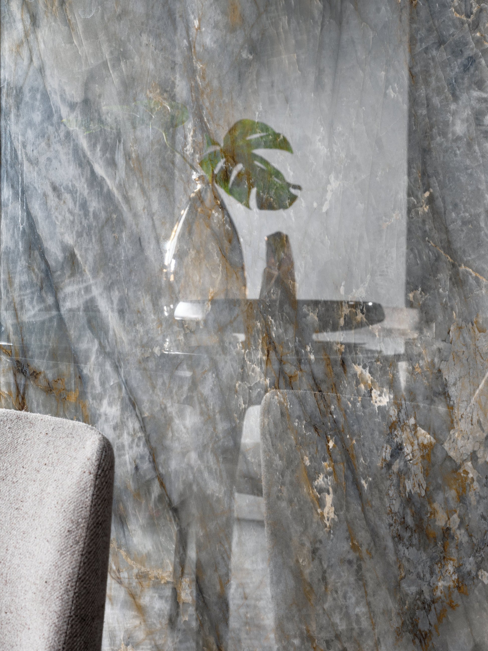 Decorative glass panel with a plant design on a marble wall.