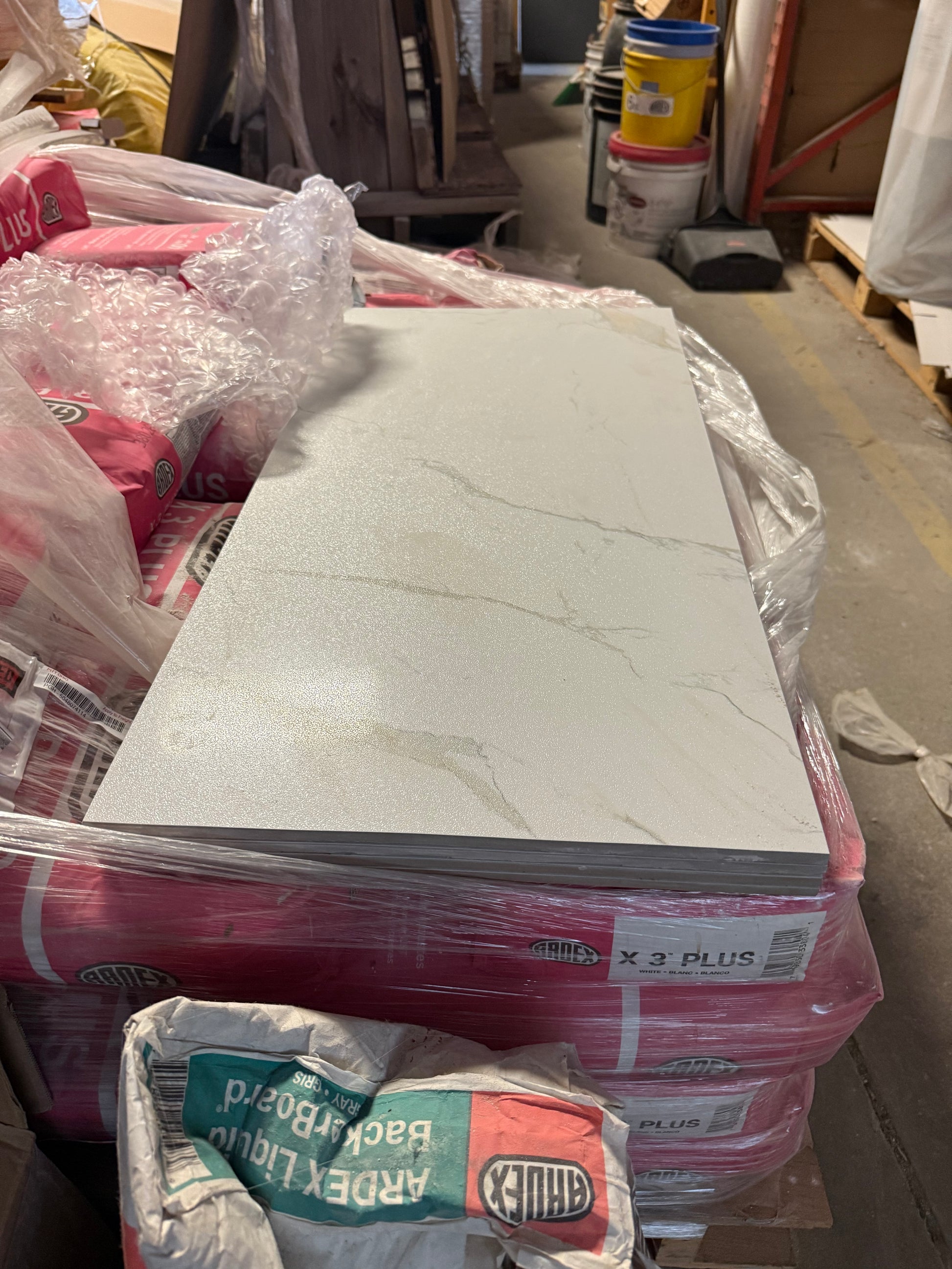 Stack of tiles with packaging materials on a cluttered background