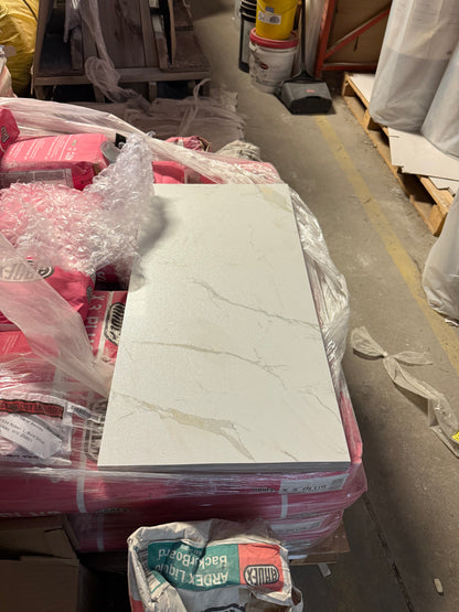 Marble-patterned tile in a warehouse setting with packaging materials.