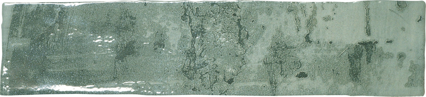 A rectangular ceramic subway tile with a green glaze.