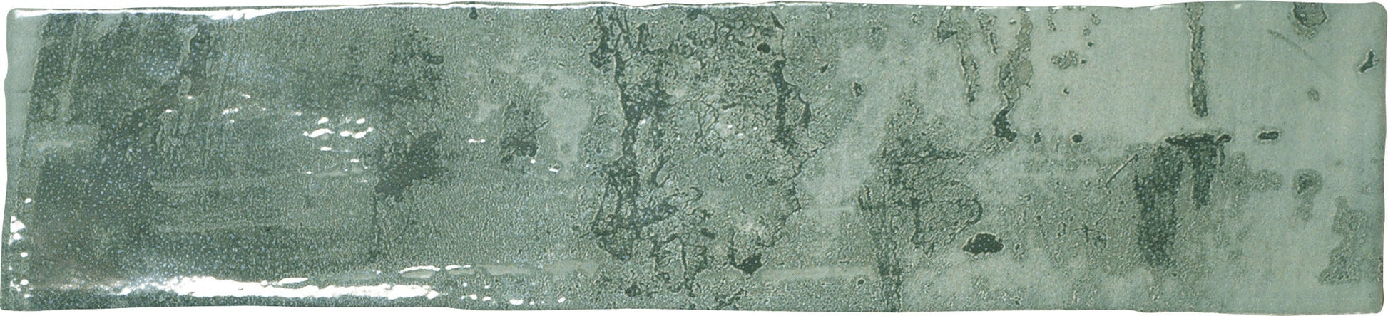 A rectangular ceramic subway tile with a green glaze.
