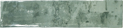 A rectangular ceramic subway tile with a green glaze.