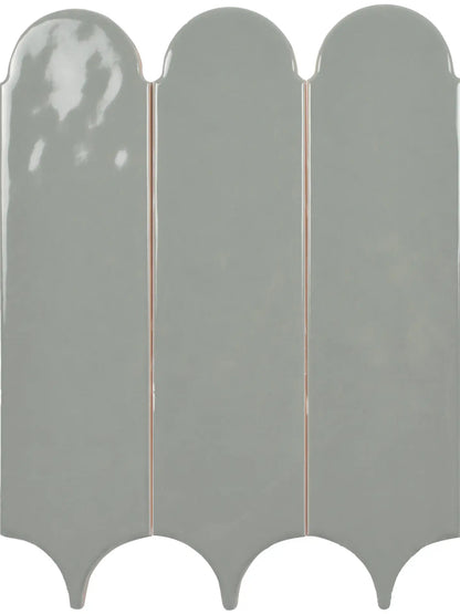 Three glossy, vertically oriented ceramic wall tiles with a scalloped or wavy bottom edge, shown side-by-side against a plain white background.