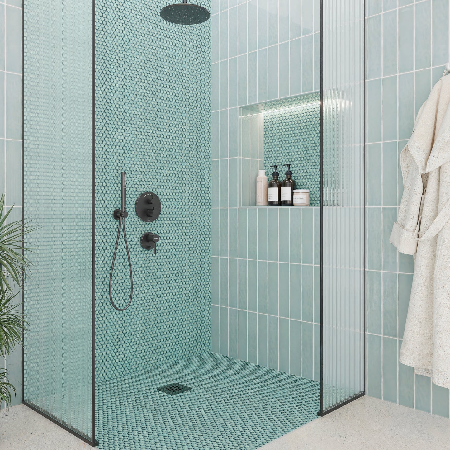 Modern bathroom with teal mosaic tiles, glass shower enclosure, and bathrobe.