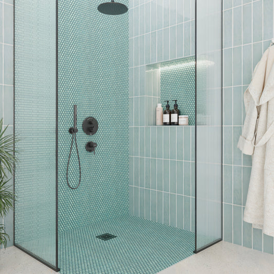 Modern bathroom with teal mosaic tiles, glass shower enclosure, and bathrobe.