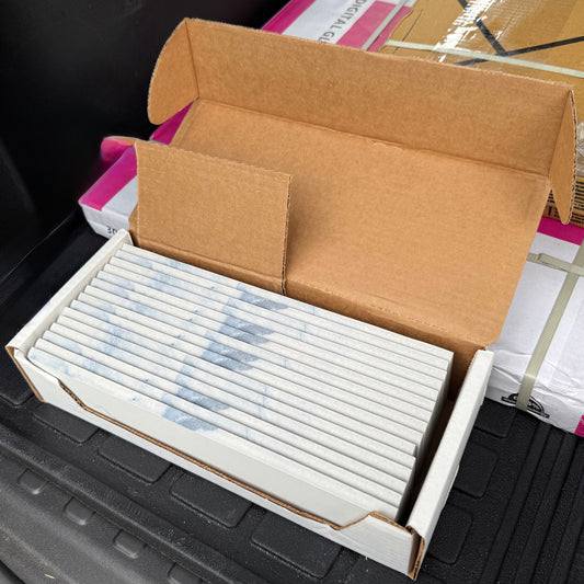 Open cardboard box with a white bullnose inside a black trunk