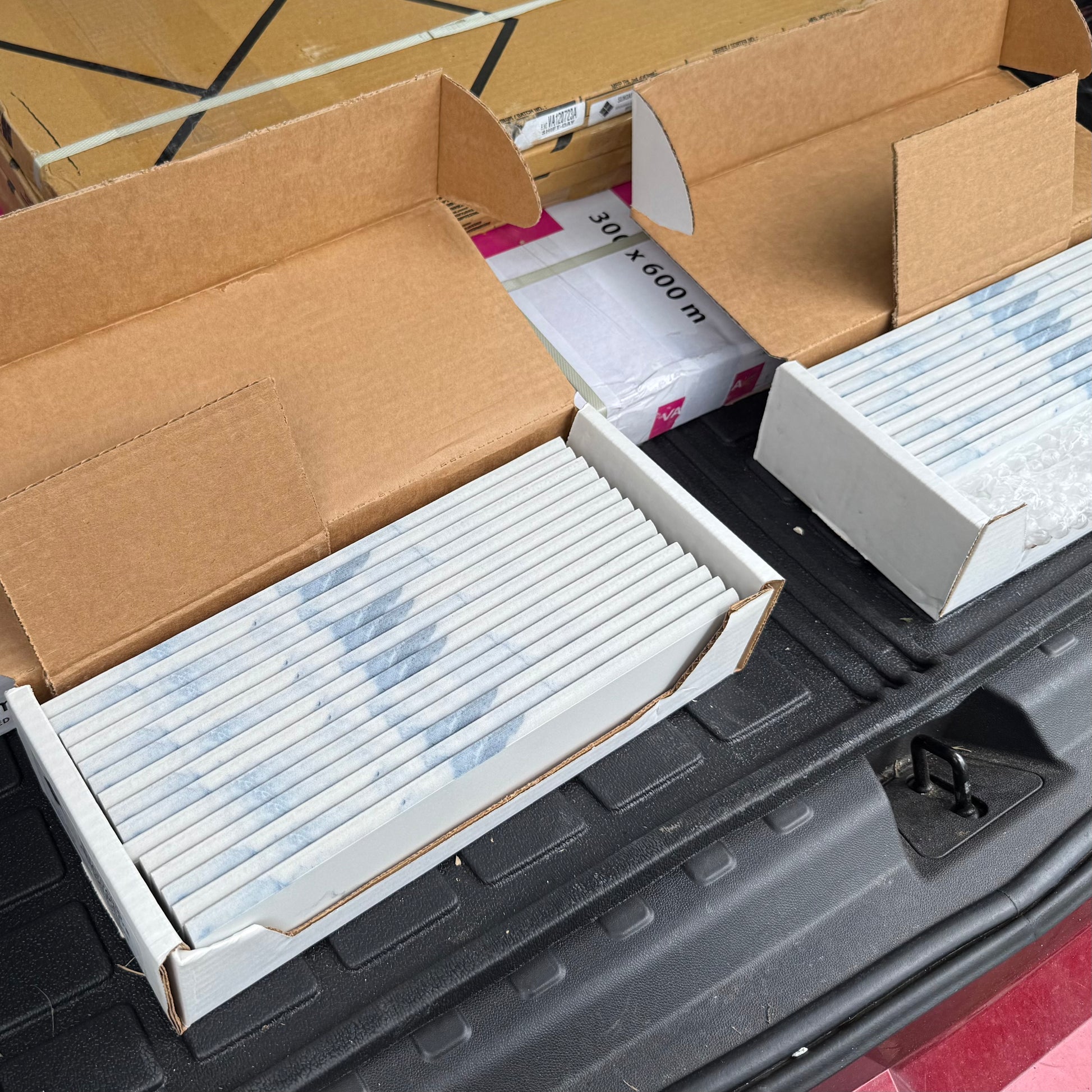 Cardboard boxes with white tile trim on a black surface