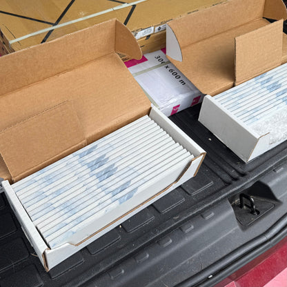 Cardboard boxes with white tile trim on a black surface