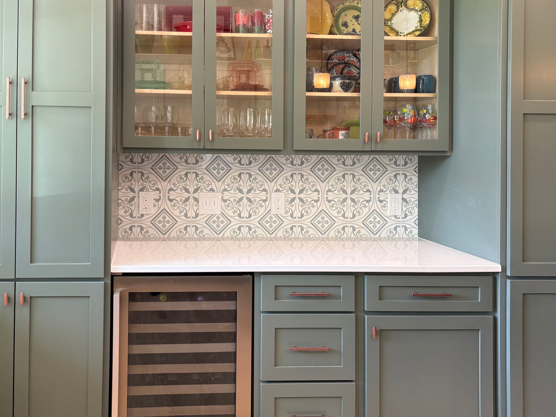 Kitchen with gray cabinets, white countertop, and patterned backsplash.