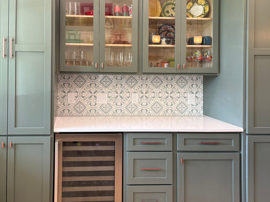 Kitchen with gray cabinets, white countertop, and patterned backsplash.
