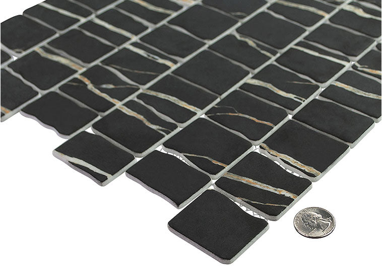 Black mosaic tile sample with a quarter for scale on a white background
