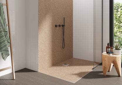 Modern shower with mosaic tile wall, wooden stool, and greenery outside.