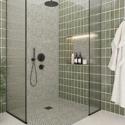 Modern shower with green tiled walls and a white bathrobe.