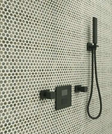 A close-up of Sage Green 1x1 Penny tiles with a shower head and hose attached, installed on a wall.
