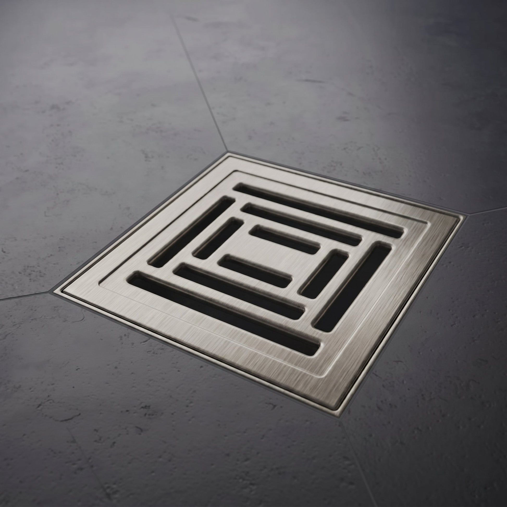 Square metal drain cover on a gray concrete floor