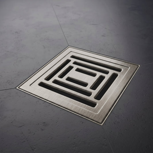 Square metal drain cover on a gray concrete floor