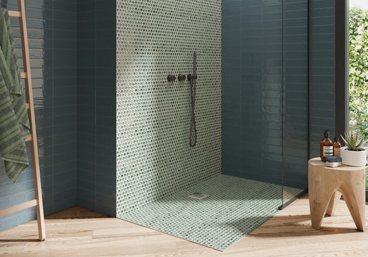 Modern outdoor shower with green mosaic tiles and wooden stool with bottles.
