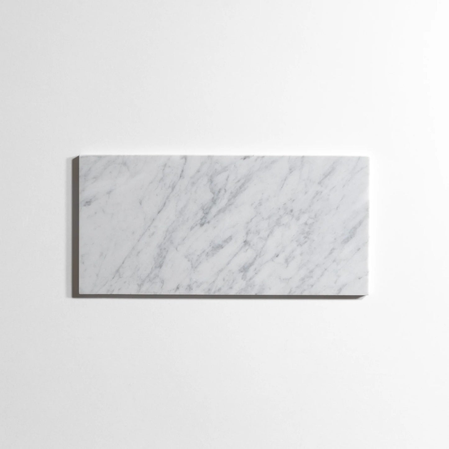 A rectangular white marble tile with elegant gray veining, displayed against a clean white background.