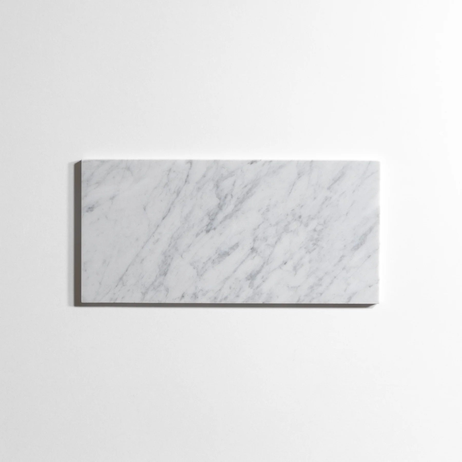 A rectangular white marble tile with elegant gray veining, displayed against a clean white background.