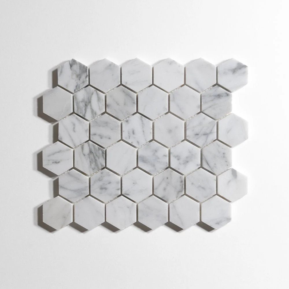 Hexagonal white marble mosaic tile sheet with natural gray veining, displayed on a clean white background.