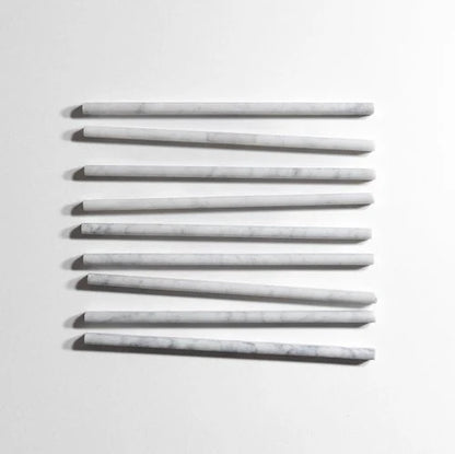 Seven long, slender rectangular bars with rounded ends, arranged in a staggered vertical row on a plain white background. The bars have a light gray to off-white color with subtle white veining, resembling marble or stone.