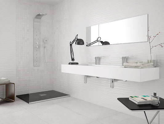 Modern bathroom with white tiled walls, a floating vanity, and a mirror.