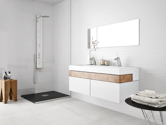 Modern bathroom with white vanity, mirror, and shower area.